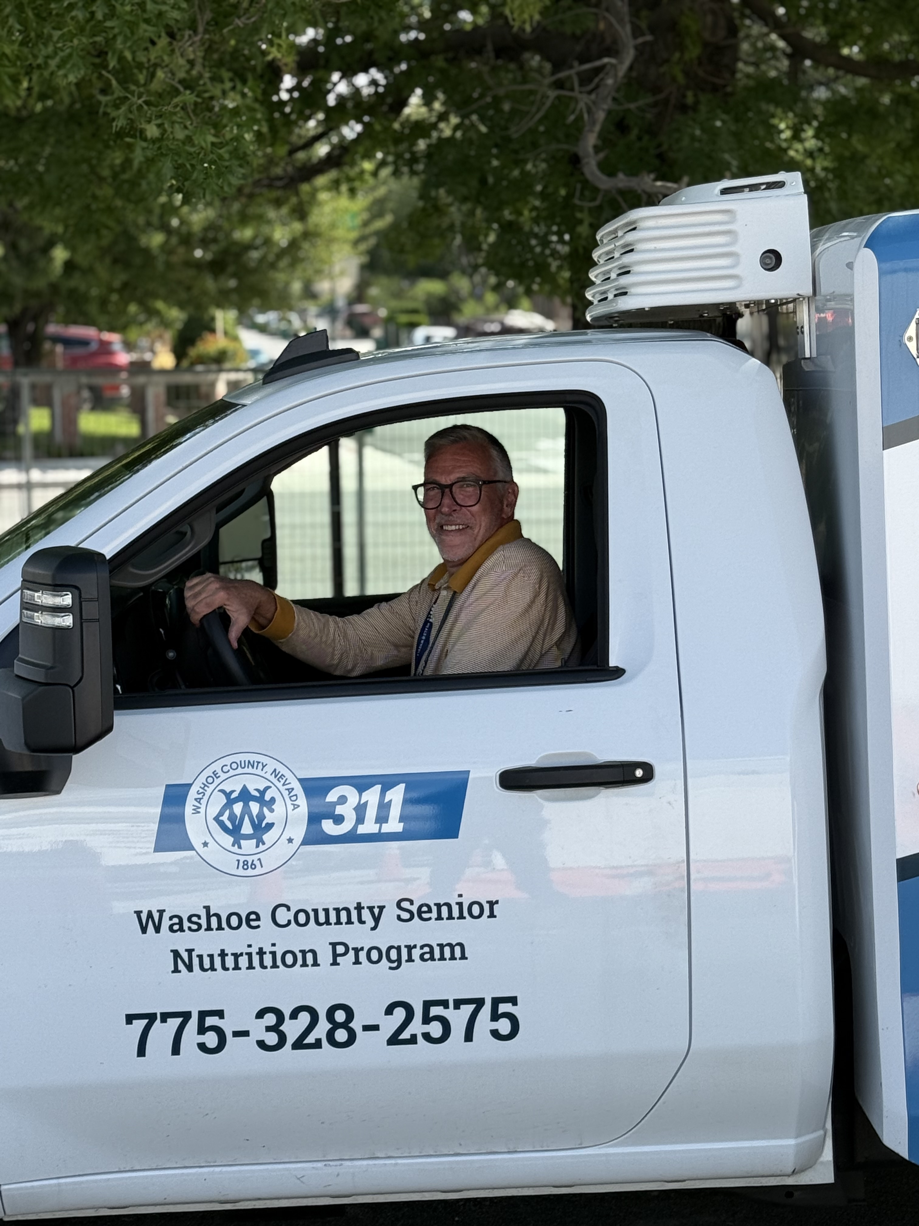 Image of a worker driving a meal delivery truck
